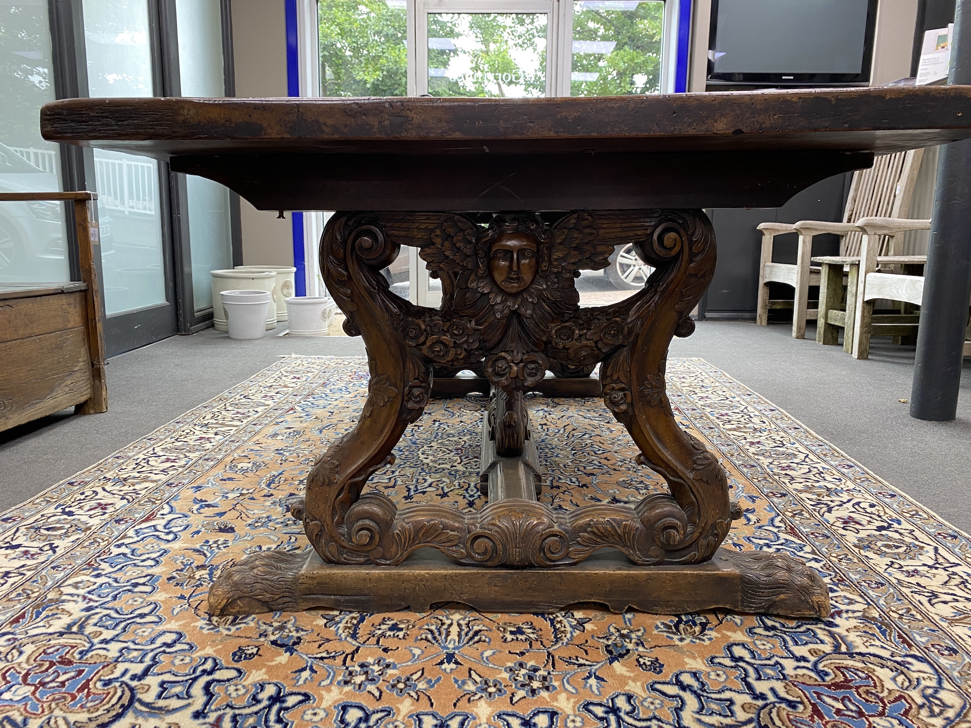 A 17th century style Italian design walnut refectory dining table, with carved angel head underframe on lion's paw feet, length 200cm, width 112cm, height 74cm